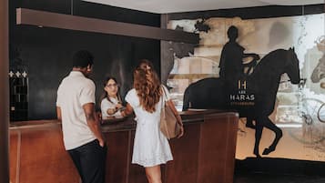 A reception area with a modern design, featuring a reception desk and a large wall mural with a horse silhouette.