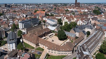 A historic town center with a prominent church tower, a mix of traditional and modern buildings, and a central square with a large open space.
