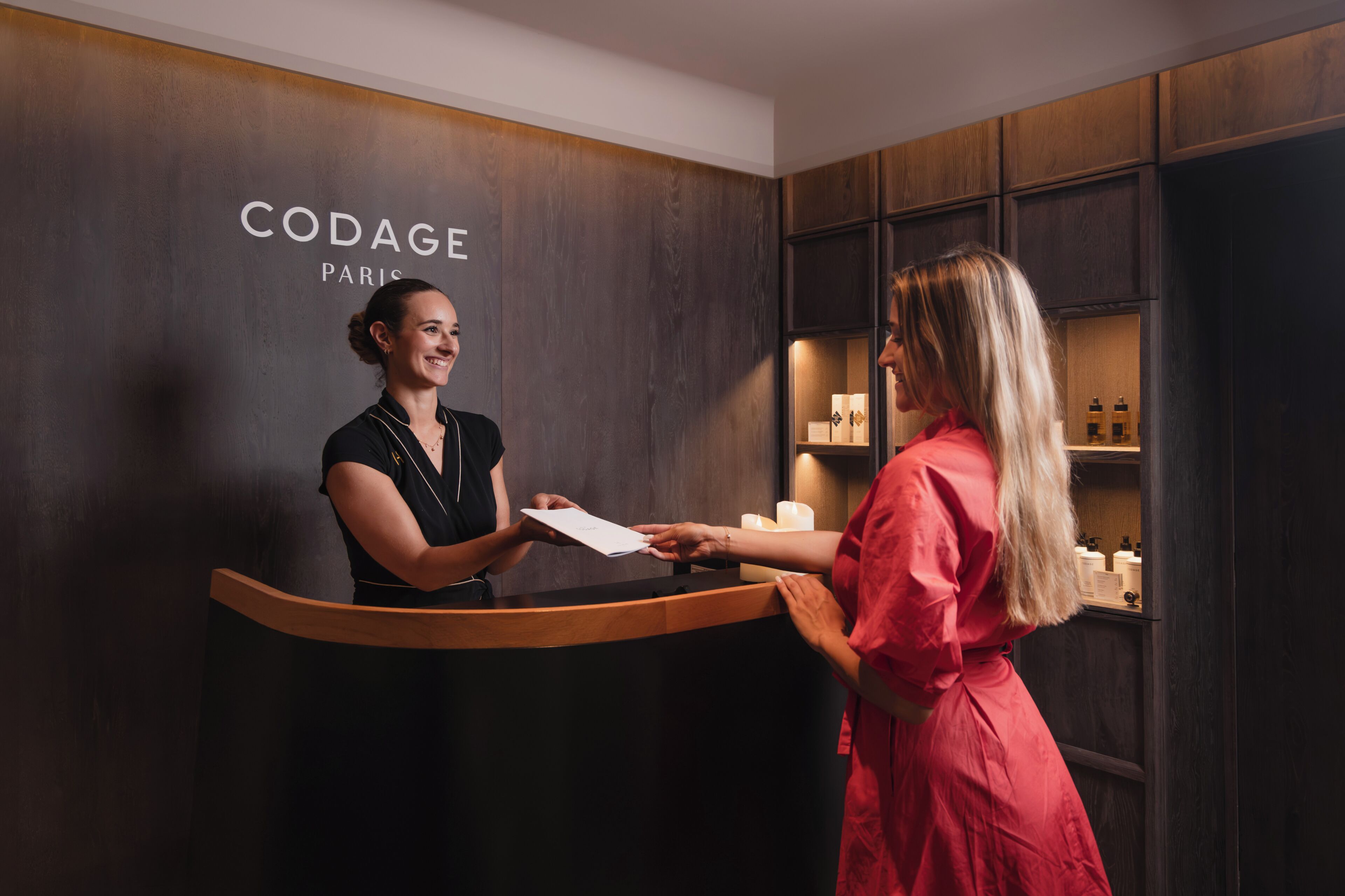 A reception desk with a wooden counter and a wall displaying 'CODAGE PARIS'.
