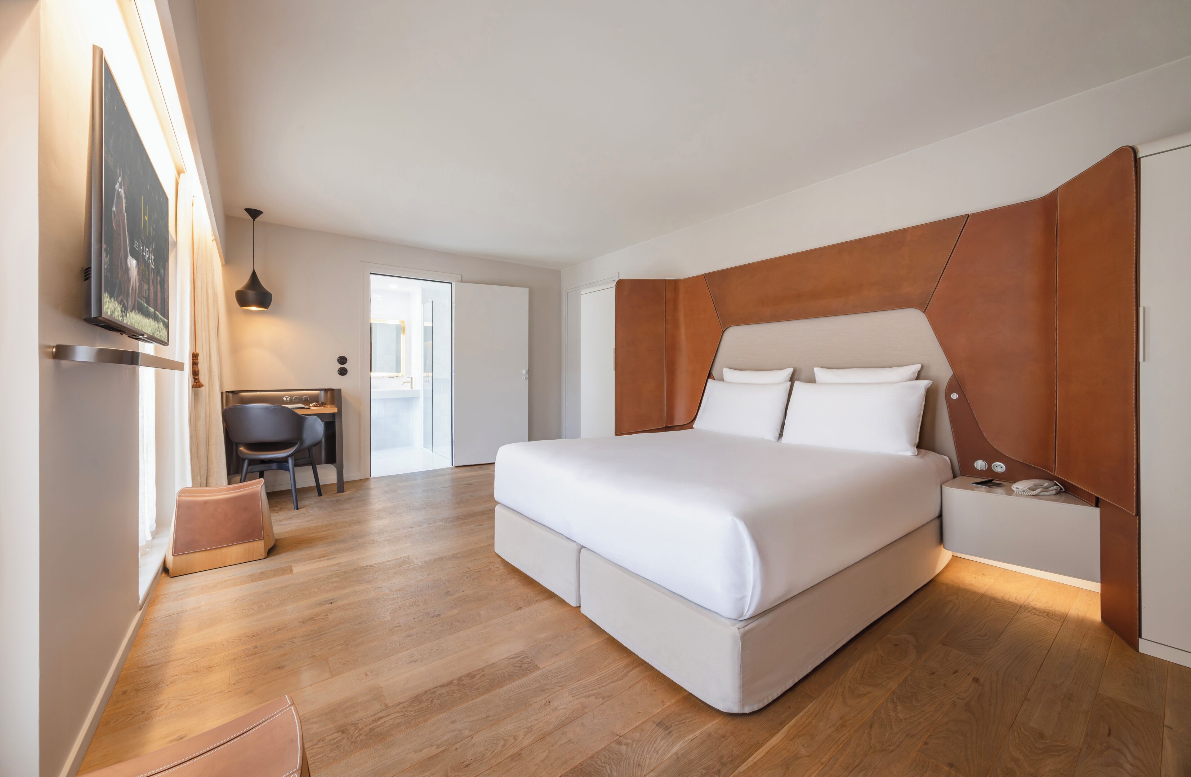 Un dormitorio moderno con una cama grande, un escritorio y una silla.