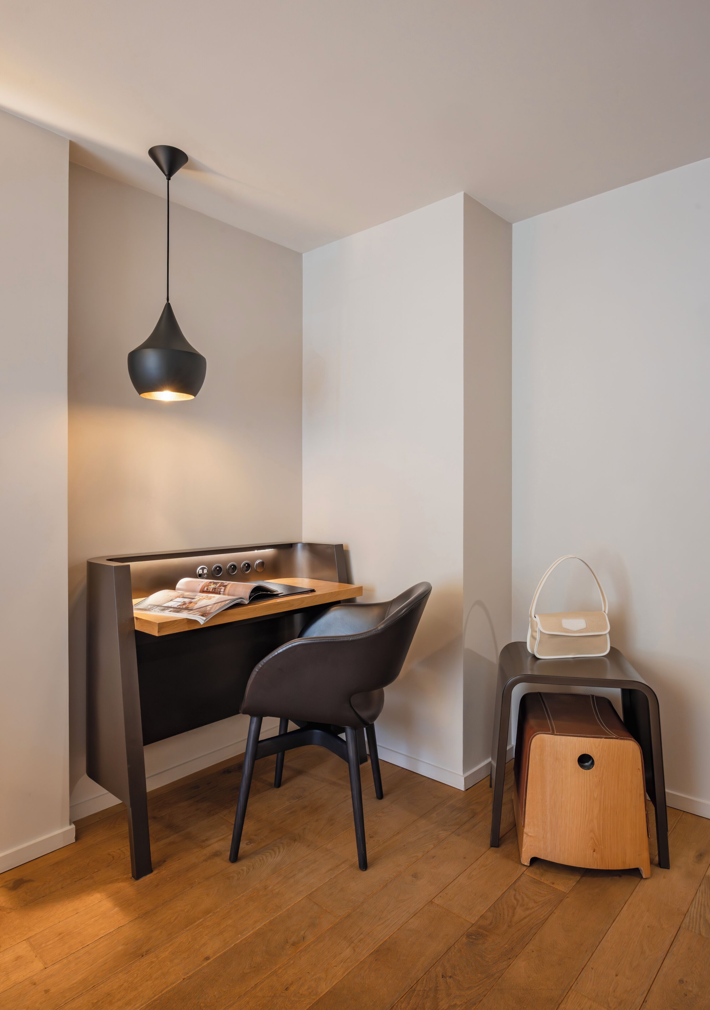 Une petite pièce moderne, équipée d’un bureau, d’une chaise et d’un luminaire suspendu.