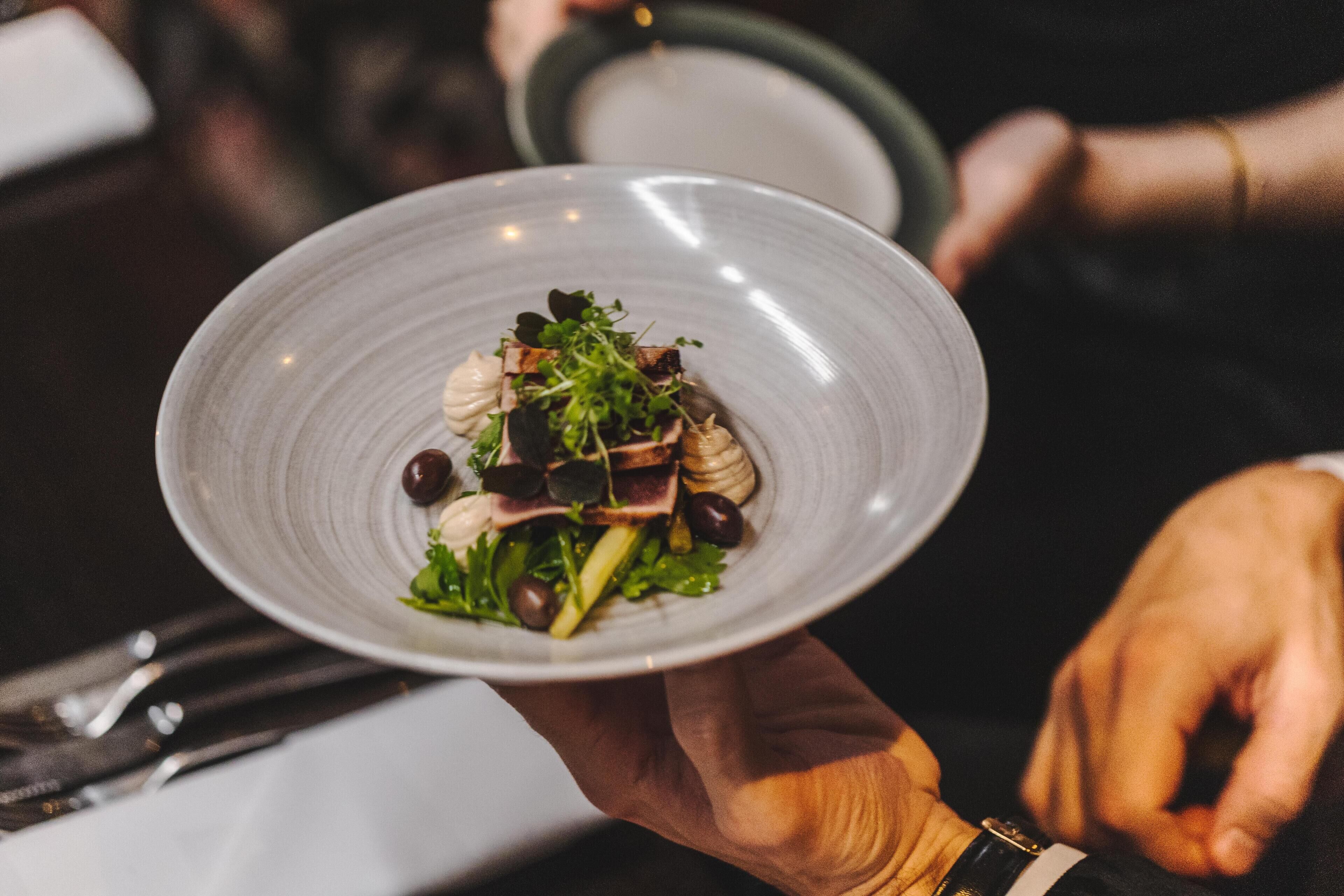A person holding a plate of food.