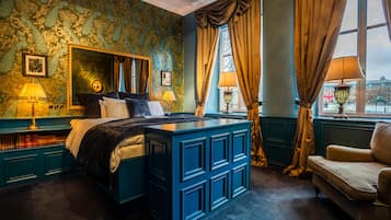 Un dormitorio con una cama grande, un aparador, un tocador y una ventana con cortinas.