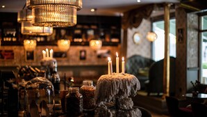Un área de bar con una pieza central de piedra, velas y un candelabro.