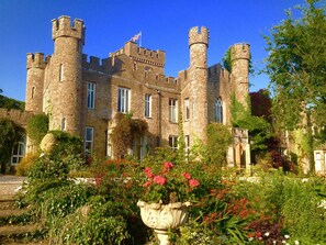Un château historique doté de nombreuses tours et d’un jardin bien entretenu, où l’on peut admirer une grande variété de plantes et de fleurs.