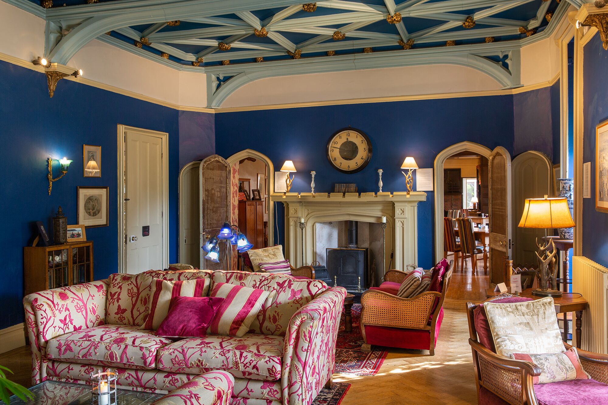 Una stanza con soffitto blu, un camino e un divano rivestito di fiori.