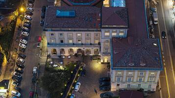 Vista aerea di un hotel con diversi parcheggi, un cortile centrale e un edificio imponente con un tetto caratteristico.