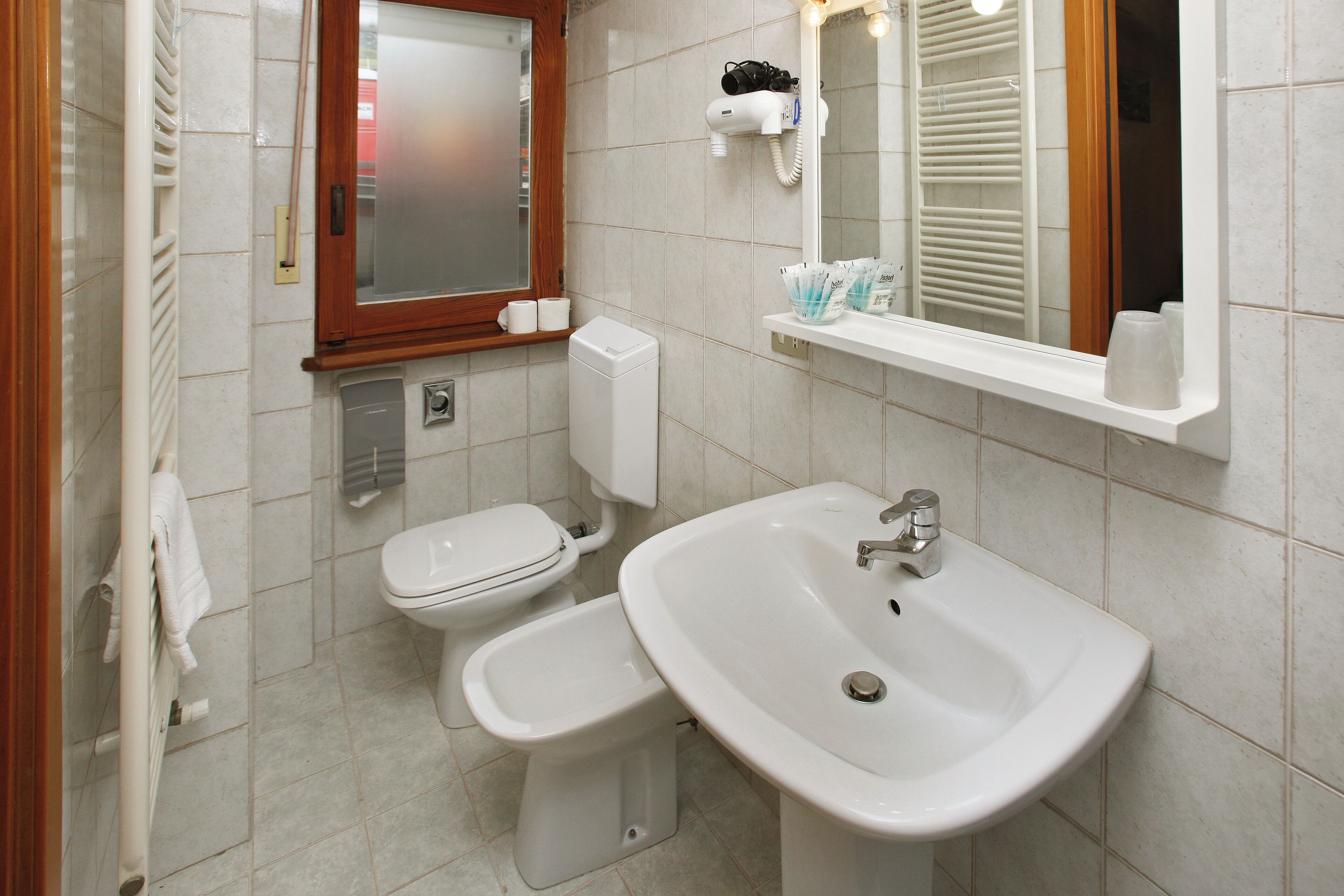 A bathroom with a toilet, bidet, and sink.