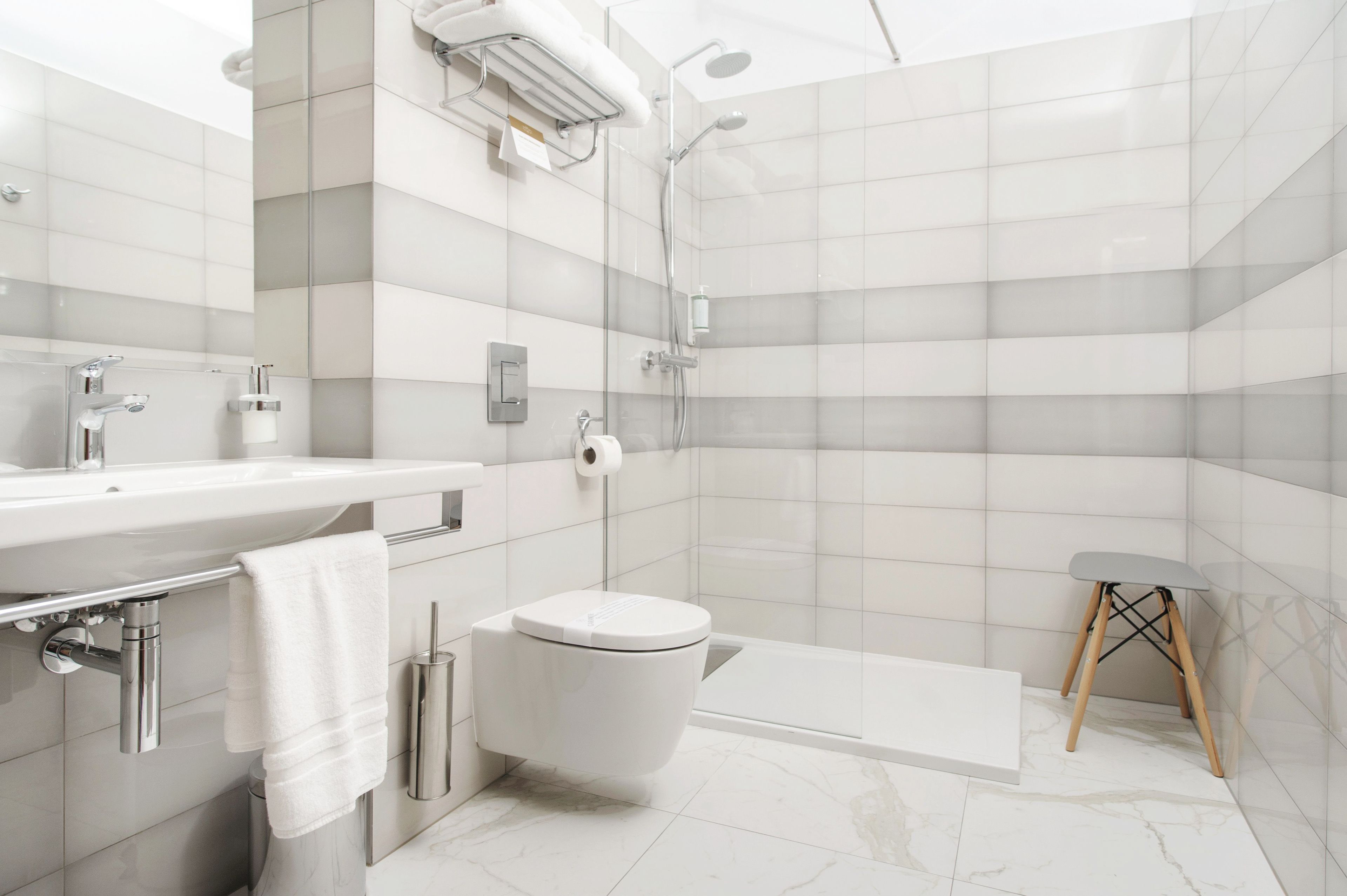A modern bathroom with a shower, toilet, and sink.