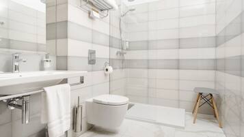 A modern bathroom with a shower, toilet, and sink.