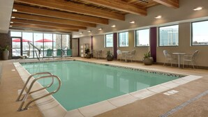 An indoor swimming pool with a wooden ceiling, clear windows, and a seating area with chairs and tables. - Home2 Suites by Hilton Salt Lake City/South Jordan, UT (South Jordan)