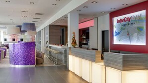 A modern hotel reception area with a bar, seating, and a large map display. - IntercityHotel Ingolstadt (Ingolstadt)