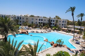 A resort with a large swimming pool, palm trees, and a building with multiple balconies. - Joya Paradise (Djerba Midun)
