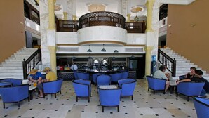 A lobby with a central bar area, seating arrangements, and a staircase. - Joya Paradise (Djerba Midun)
