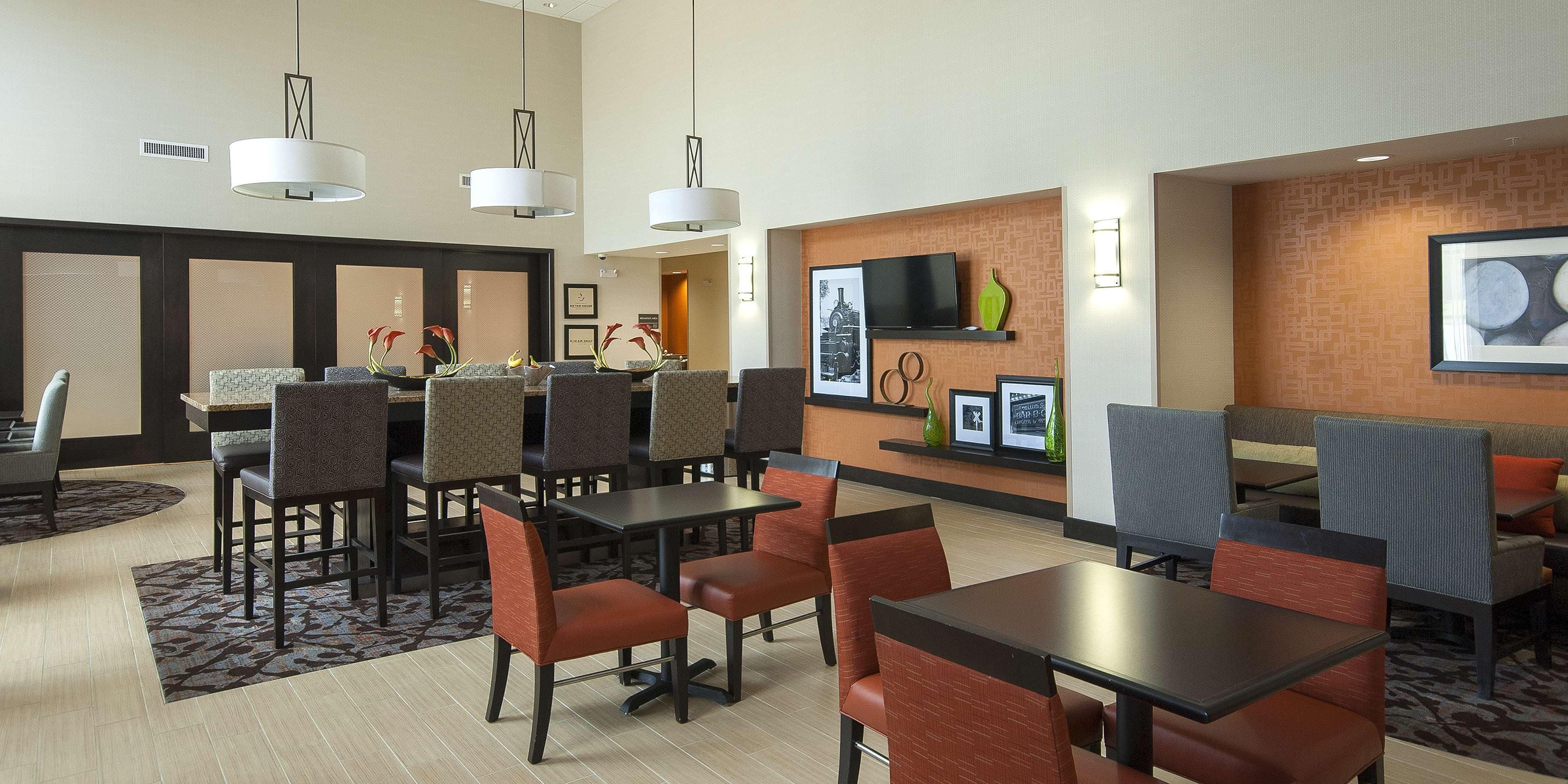 A hotel lobby with a reception desk, seating area, and a television mounted on the wall.