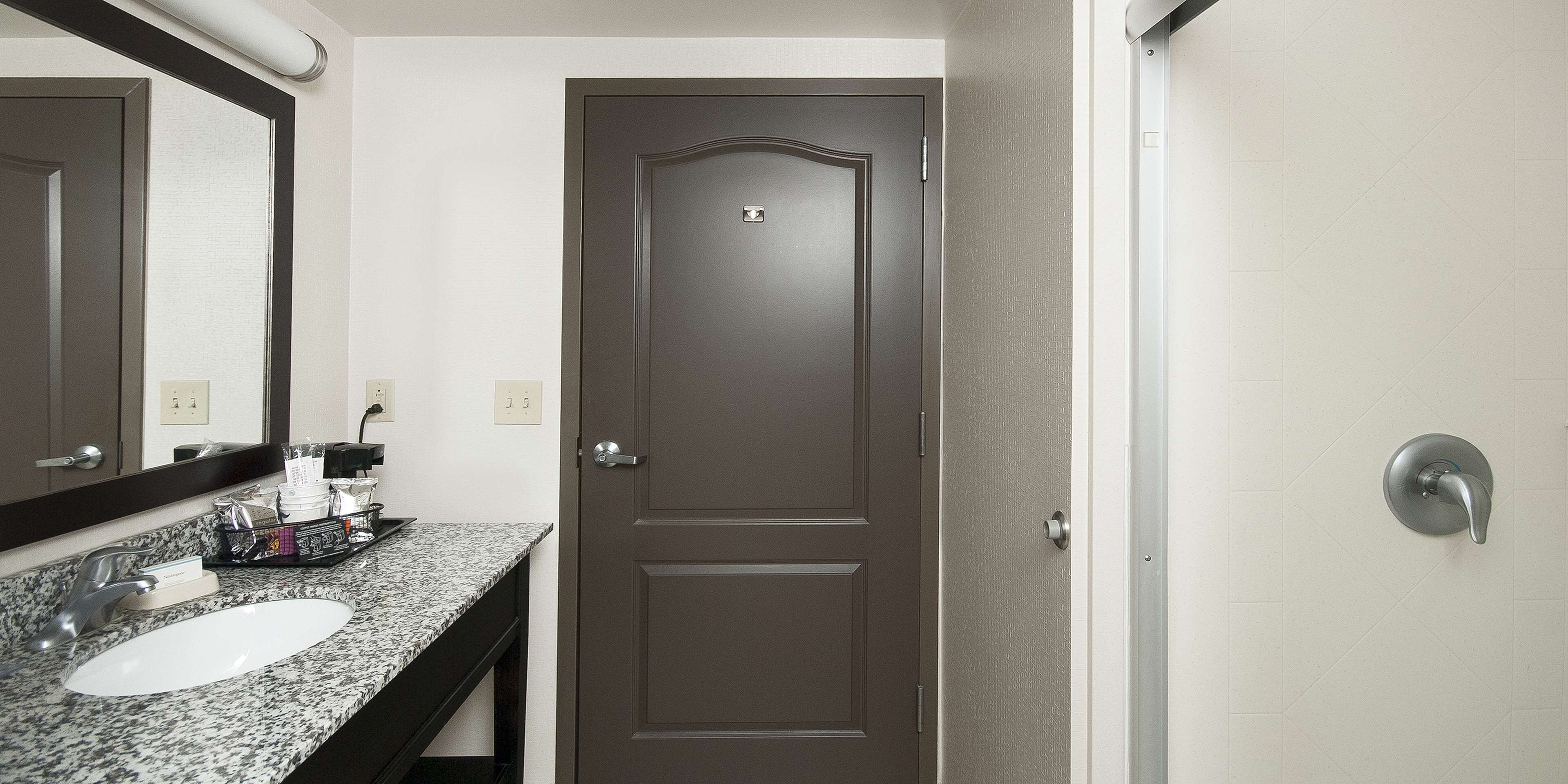 A bathroom with a dark brown door, a white sink, and a mirror above the sink.