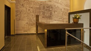 Un vestíbulo con un mural de un mapa, una recepción y una escalera.