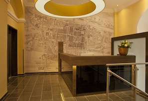 A lobby with a map mural, a reception desk, and a staircase. - Hotel Jakob Regensburg DownTown, BW Signature Collection (Regensburg)