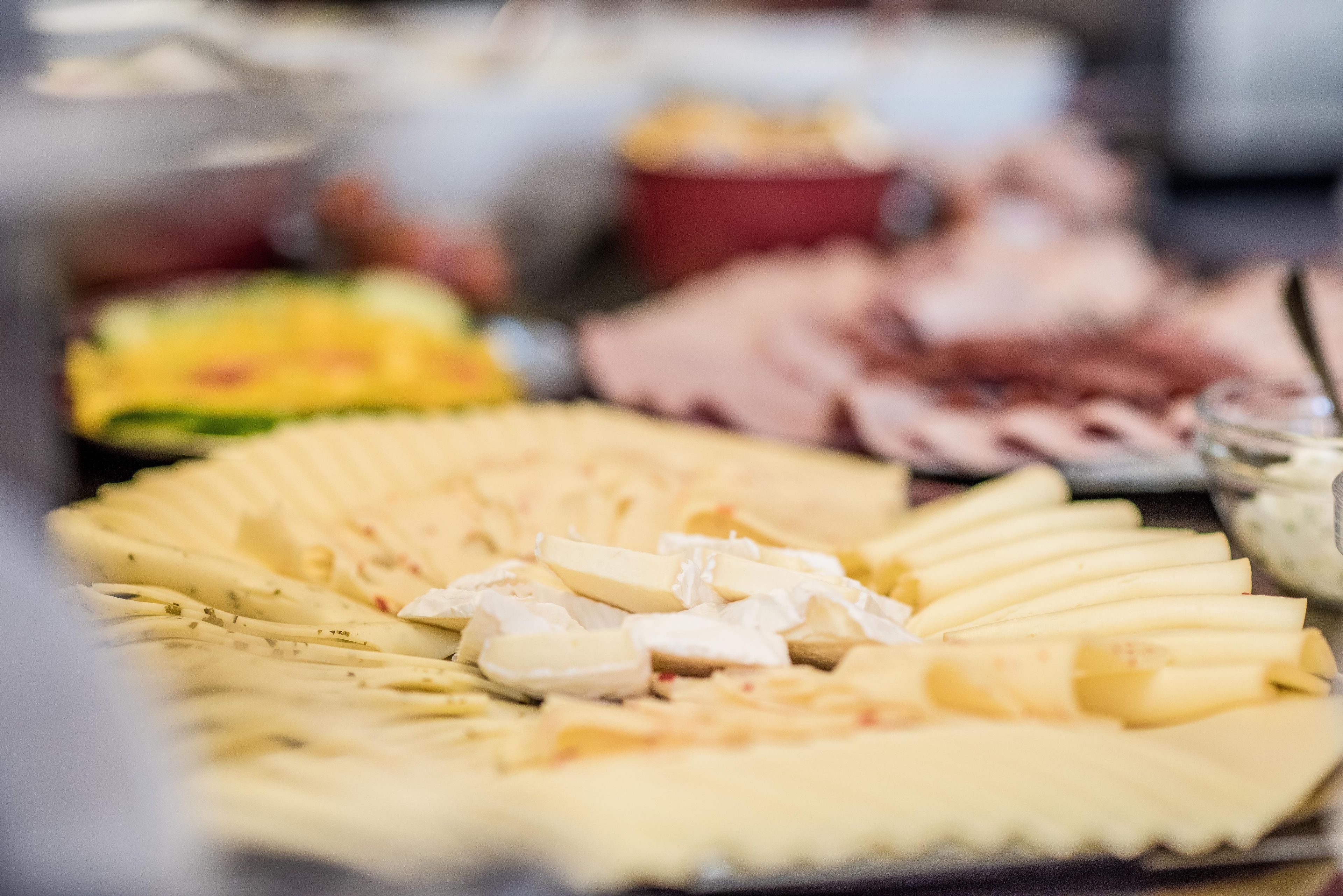 A buffet with various food items including cheese, fruits, and meats.