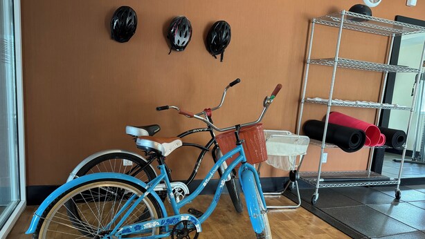 A blue bicycle with a white seat and black handlebars, leaning against a wall. - Homewood Suites by Hilton Queretaro, Mexico (Querétaro)
