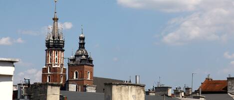 A view of a church with a tall bell tower and a smaller dome structure, surrounded by rooftops.