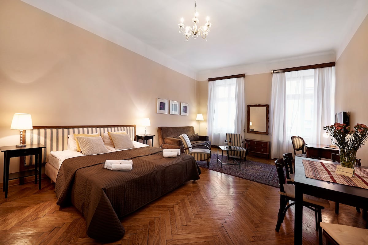 Une chambre d’hôtel avec un grand lit, un bureau, une chaise et une table à manger.