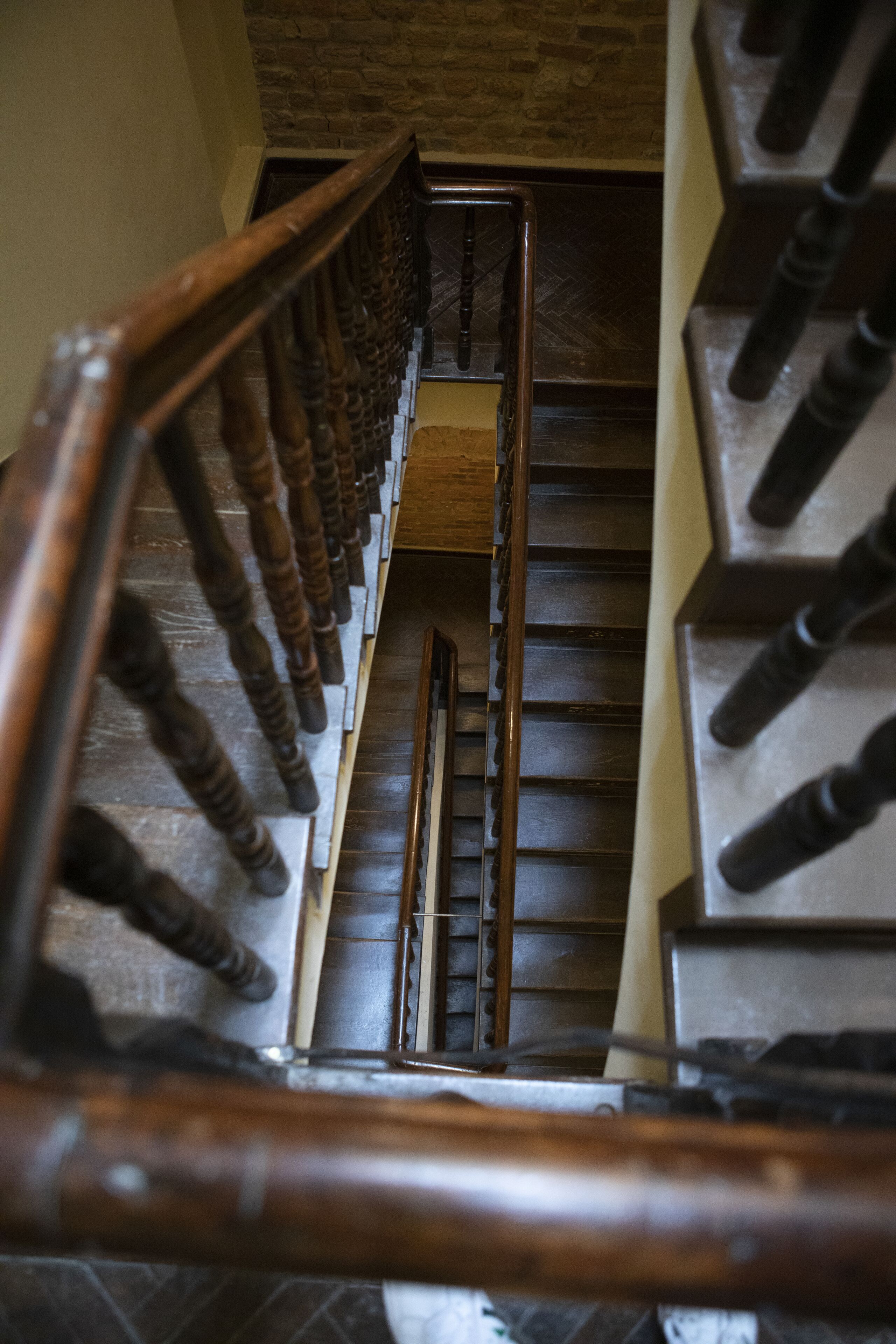 A wooden staircase with a metal handrail and a wooden floor.