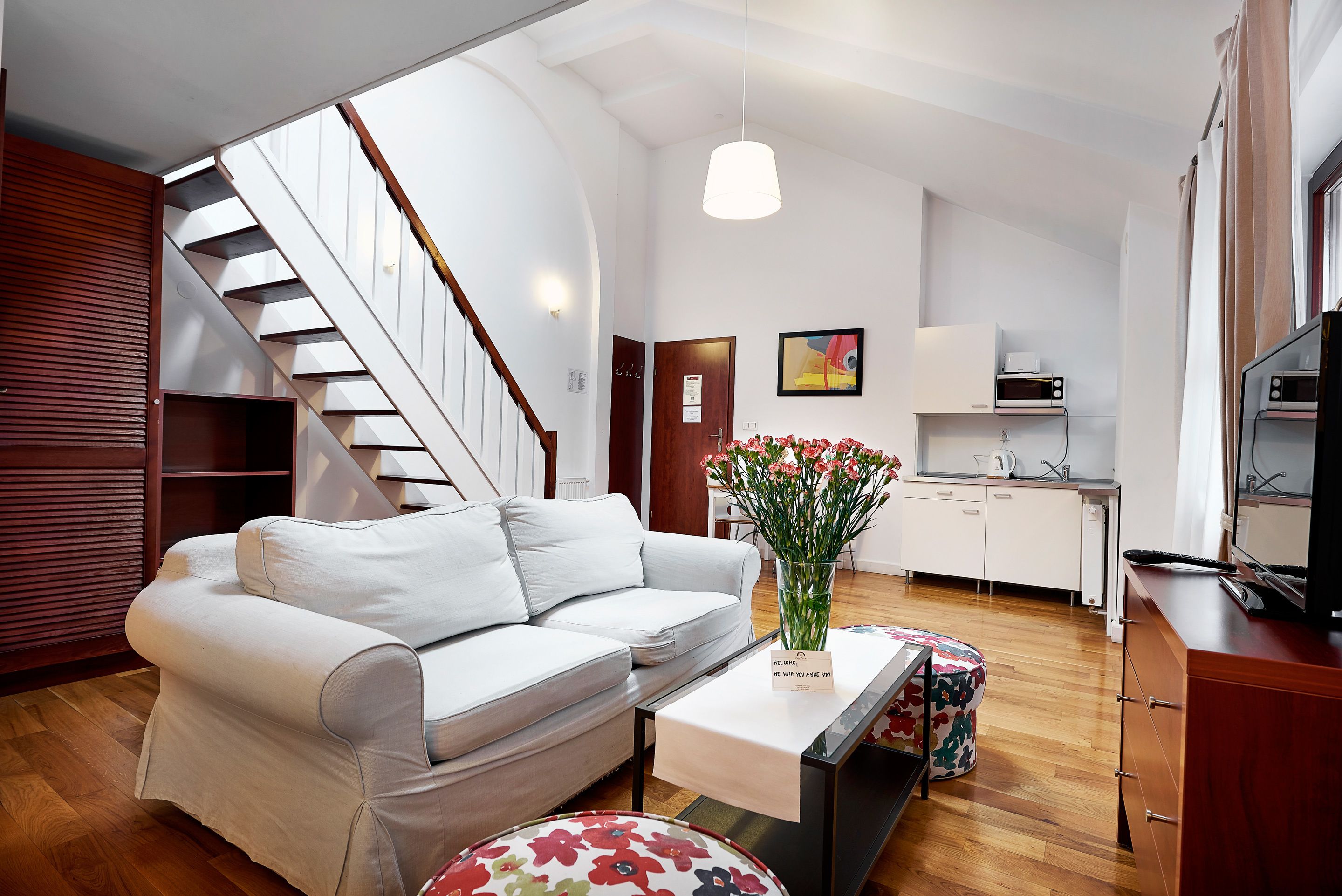 Een moderne woonkamer met een bank, een salontafel en een trap.