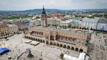 A large public square with historic buildings, a prominent tower, and a central fountain.