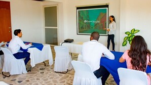 A conference room with white chairs, a projector screen, and a presentation. - Hotel U Xul Kah (Campeche)