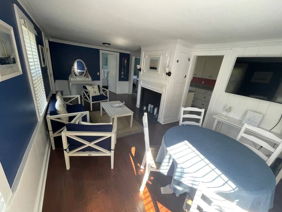 A room with a dining table, chairs, a fireplace, and a view of the outside.