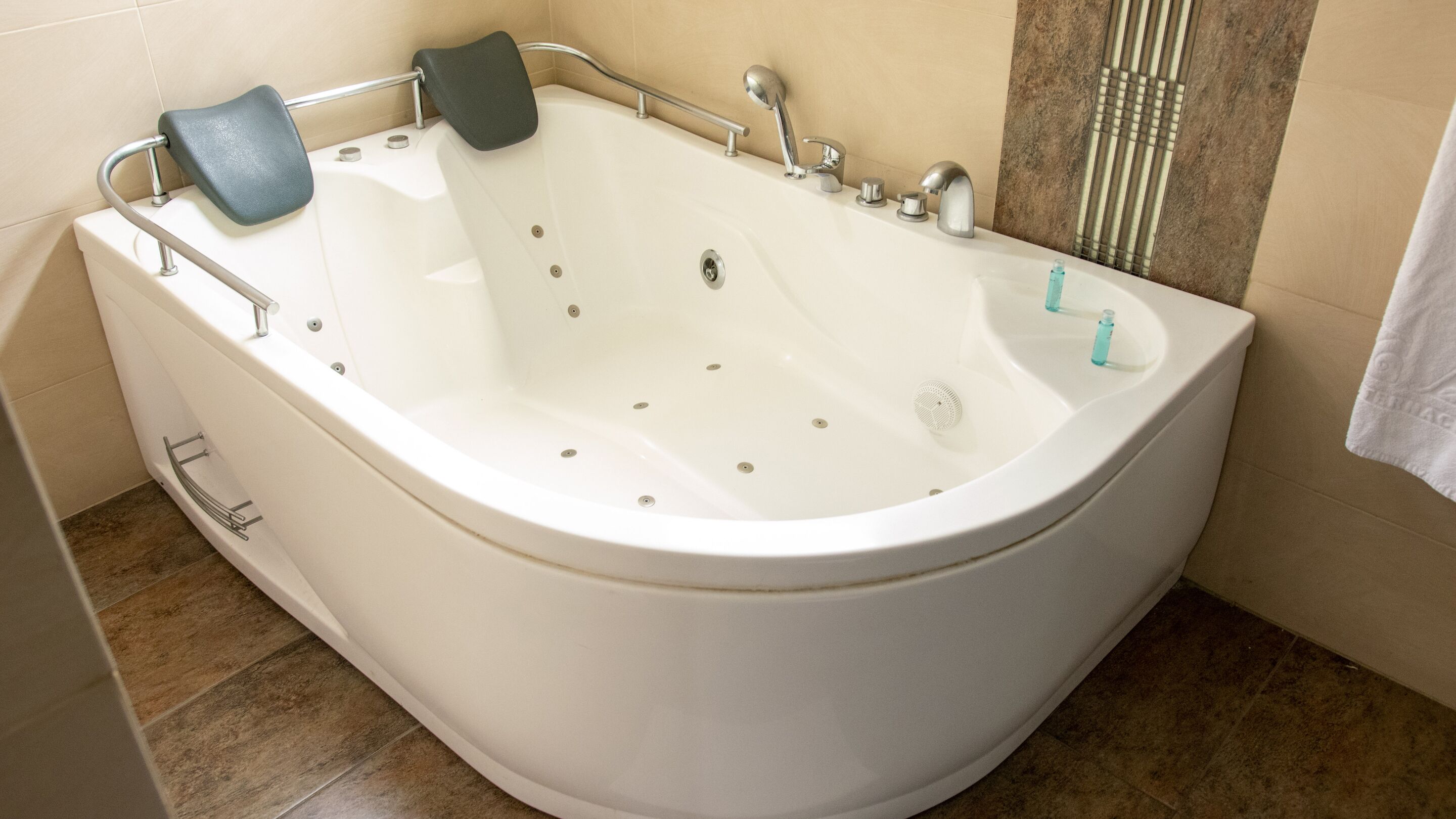 A modern bathroom with a freestanding bathtub, a shower area, and a towel rack.