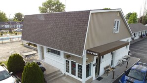 A two-story building with a brown roof and beige siding, labeled "OFFICE" on the front. - Falcon Inn (Niagara Falls)