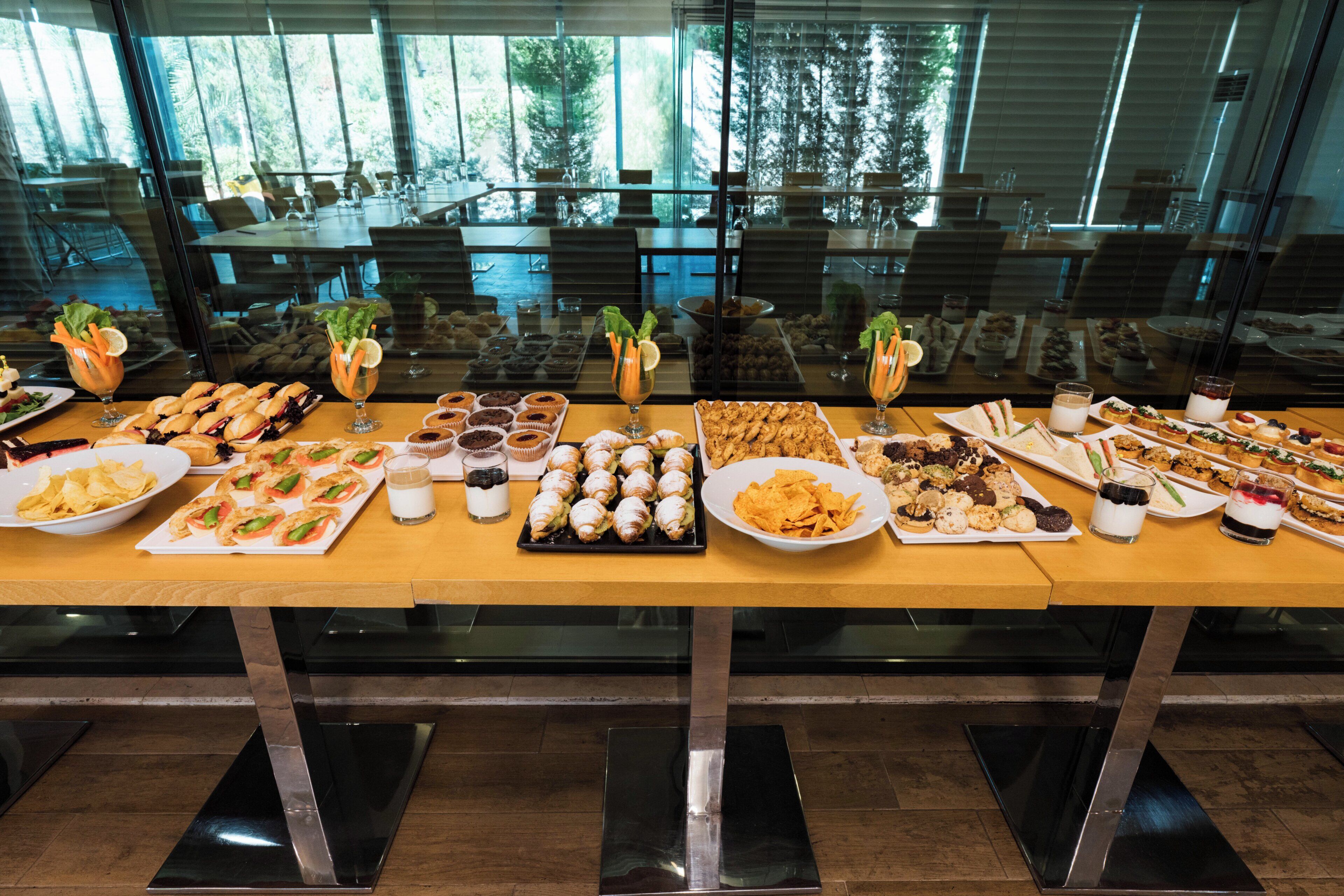 A buffet table with various food items and drinks.