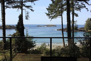 A coastal view with a beach, rocky outcrops, and dense trees. - Wya Point Resort (Ucluelet)