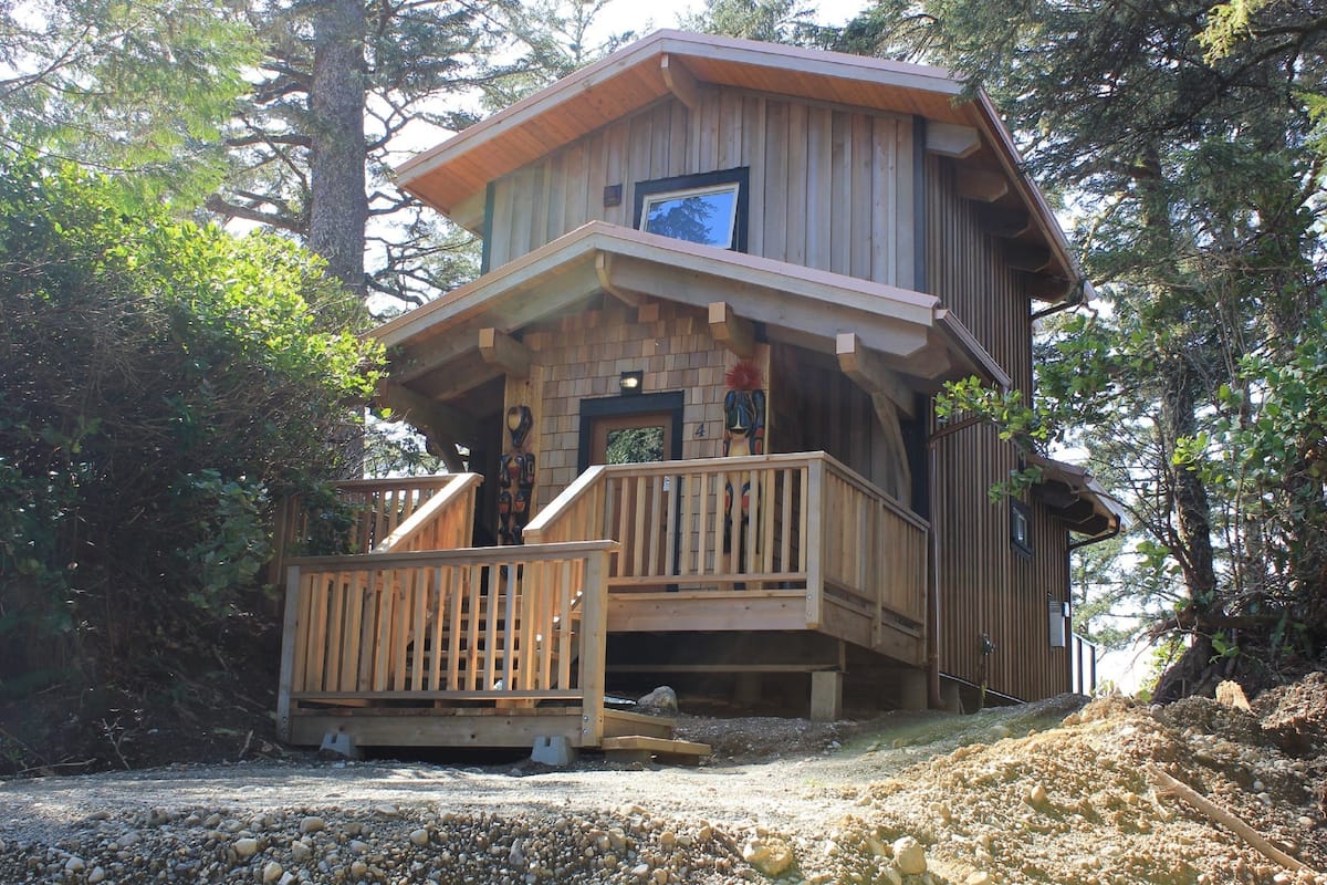 Eine Holzhütte mit einem Balkon, umgeben von Bäumen.