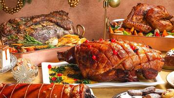 A festive meal with roasted meats, vegetables, and various desserts.