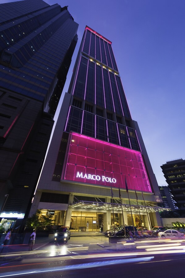 Un edificio alto con un llamativo letrero de 'Marco Polo' en la fachada.