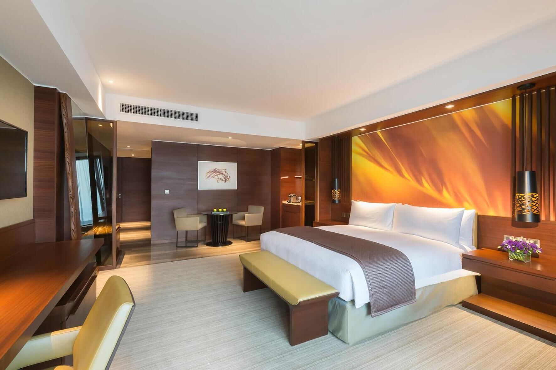 Een moderne hotelkamer met een groot bed, een bureau en een zithoek.