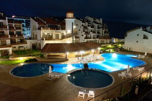 Een resort met een zwembadgedeelte, een overdekte zithoek en een vuurtoren.