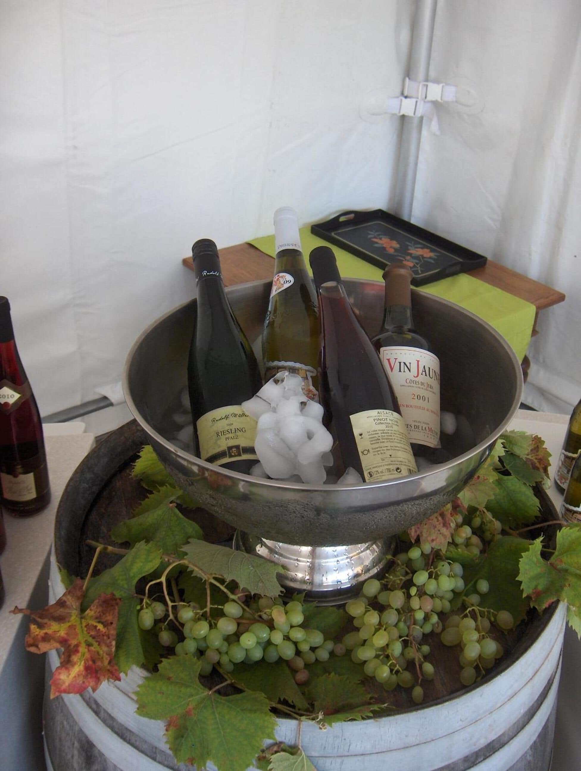 Une présentation de vins avec des bouteilles et des grappes de raisin.