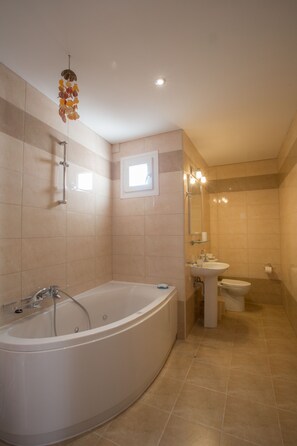 A modern bathroom with a freestanding bathtub, a sink, and a toilet. - Gouvia (Corfu)