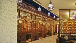 A lobby with patterned partitions, a seating area, and hanging lanterns. - Salalah Gardens Hotel Managed by Safir Hotels & Resorts  (Salalah)