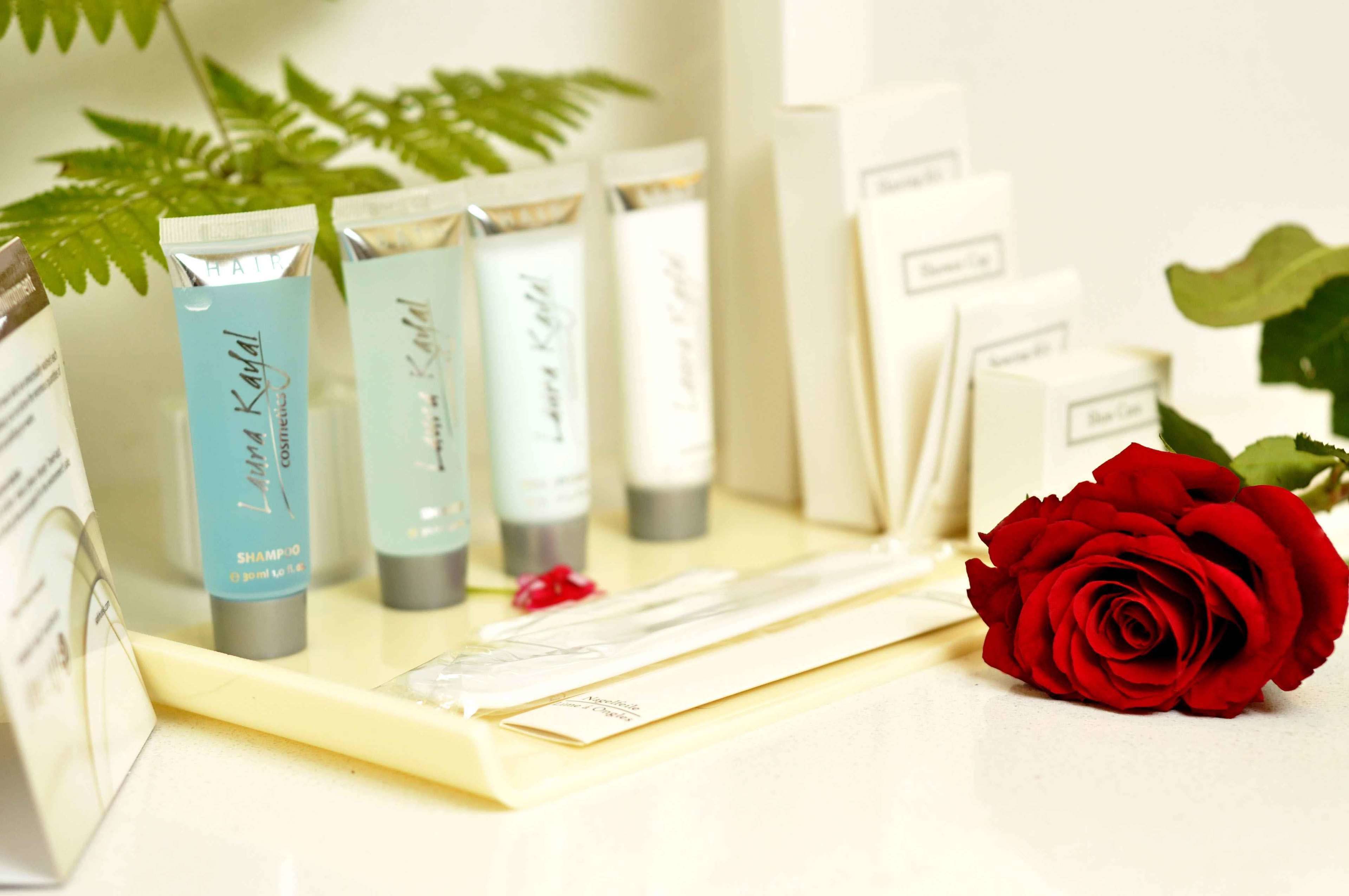 A display of hair care products with a red rose.
