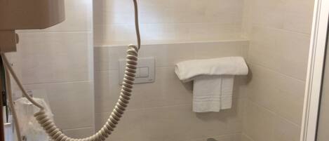Un baño con lavamanos, inodoro, bidé y secador de pelo.