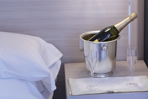 A champagne bottle in a metal bucket on a bedside table with two glasses. - Twelve Hotel (Moncalieri)