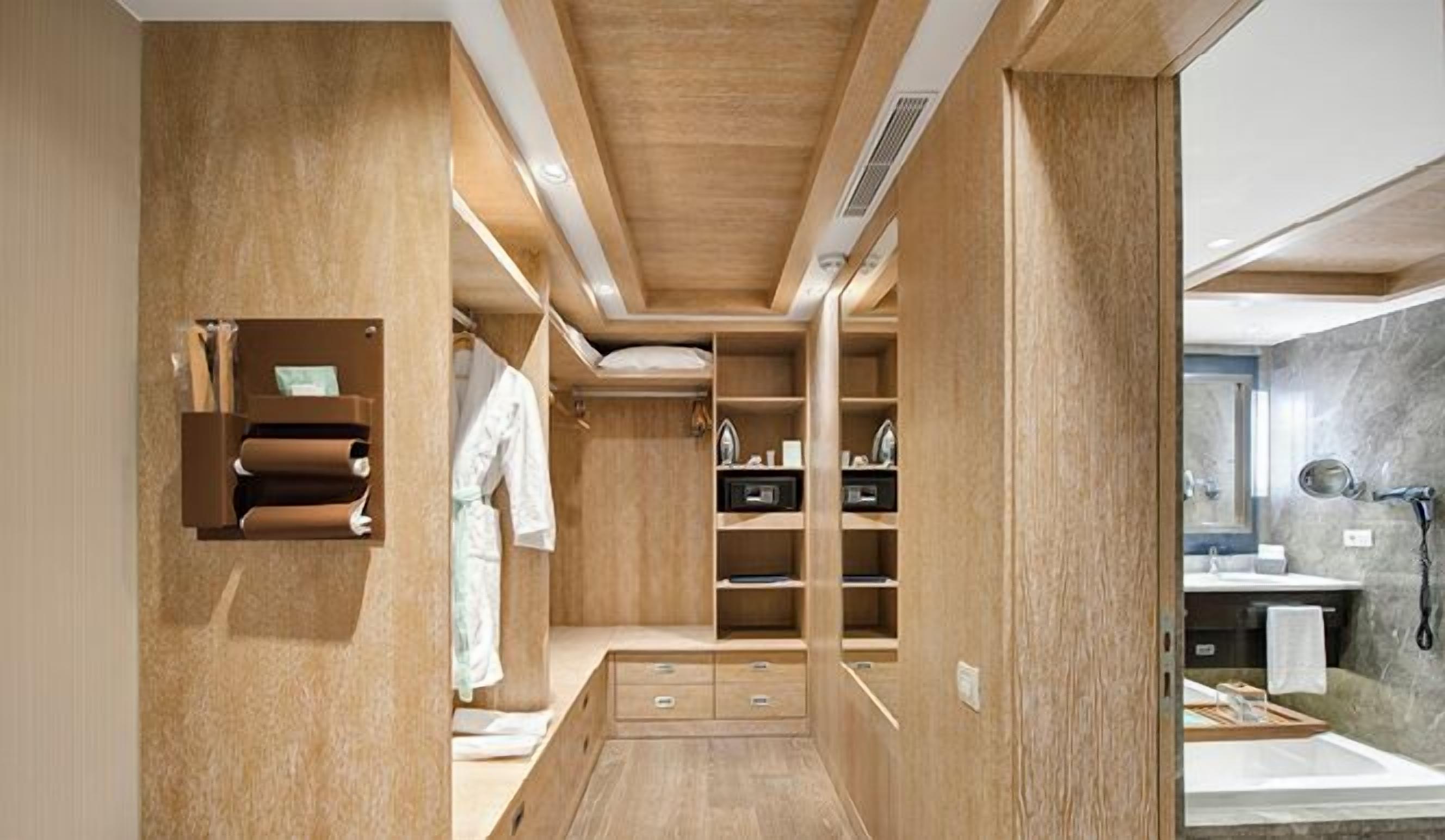 A modern bathroom with a wooden vanity, a mirror, and a sink.