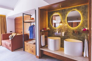 A modern bathroom with two sinks, a large mirror, and a wooden vanity.