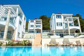 A modern hotel with a swimming pool, multiple balconies, and outdoor seating areas. - Orka Sunlife Resort hotel and Aquapark (Fethiye)