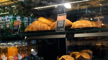 Una vitrina de panadería con distintos productos horneados y bebidas.